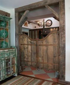 an old wooden door is opened to reveal a room with a clock on the wall