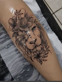 a woman's leg with a lion and flowers on it