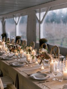 a long table is set with candles and plates