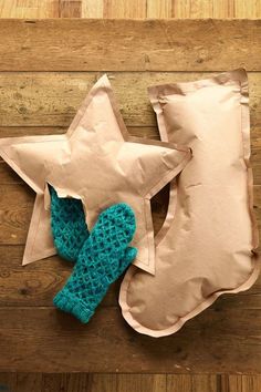 a stuffed star sitting on top of a pillow next to a pair of mittens