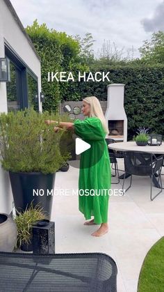 a woman in a green dress is holding a potted plant with the words ikea hack on it