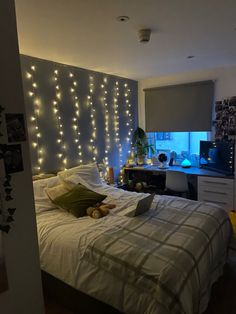 a bed room with a neatly made bed and string lights on the wall above it