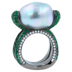 12.15 Carats Beautiful Silvery White Iridescent South Sea Pearl 16.50 x 13.50 mm Elongated Egg Oval Shape South Sea Pearl Size AAA Quality Extremely Beautiful, Captivating Pearl High-End, Luxury Crafting & Finish Green Emeralds Pave: 3.00 ctw Blue Sapphires Pave: 0.50 ctw White Diamonds Pave: 0.50 ctw 18K White Gold + Black Rhodium Plating 14.7 grams Ring Size 5.75 Sea Pearl, 18k Gold Ring, South Sea Pearls, Sea Pearls, Pearl Size, Emerald Diamond, Cocktail Rings, Pave Diamonds, Earings Piercings