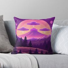 an alien landscape with trees, mountains and flying saucers throw pillow on a couch