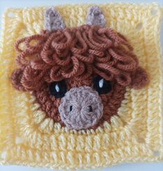 a crocheted square with a brown cow's face on it