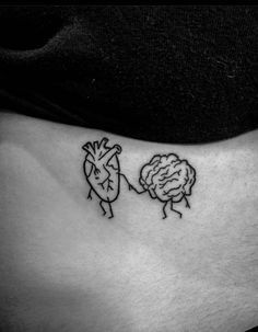 a woman's stomach with a small tattoo of two people holding hands and one has a brain on it