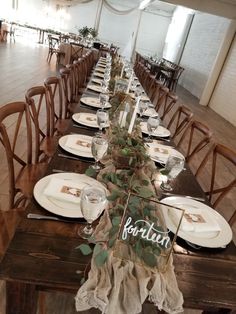 a long table set with place settings for dinner