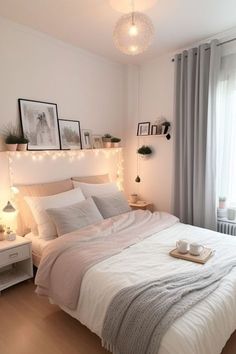 a white bed sitting in a bedroom next to a window filled with curtains and lights