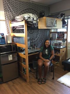 a woman is sitting in her dorm room