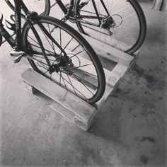 two bikes are parked on wooden benches in a garage