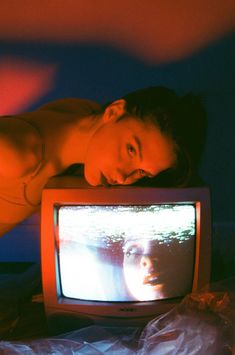 a woman laying on top of a tv