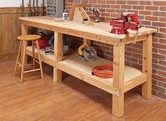 a workbench with tools on it in front of a brick wall and wooden floor