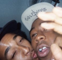 two young men are kissing each other in front of a white sticker that says love dynamite