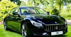 a black masera is parked in the grass