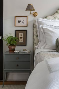 a bed room with a neatly made bed and some pictures on the wall above it