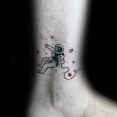 an astronaut tattoo on the ankle