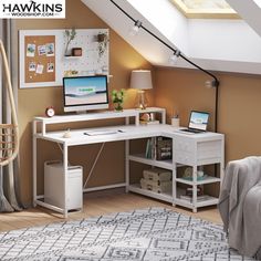 a computer desk with two computers on top of it in front of a slanted ceiling