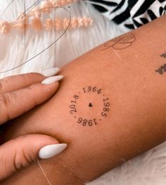 a woman's arm with a tattoo on it that reads, date and location