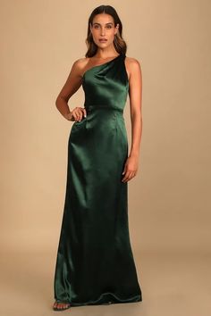 a woman in a green gown posing for the camera with her hands on her hips