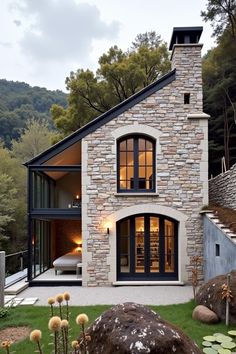 Charming stone cottage with large windows. The undeniable charm of cottage homes brings a rustic fairytale to life with each brick and beam.