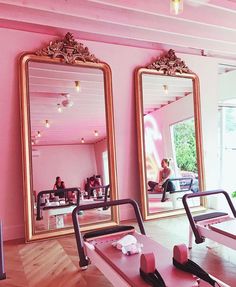 a pink room with mirrors and exercise equipment