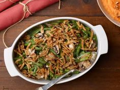 a casserole dish with green beans, mushrooms and onions in it on a wooden table