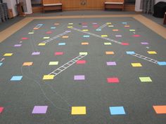 the floor is covered with multicolored squares and ladders in an empty room