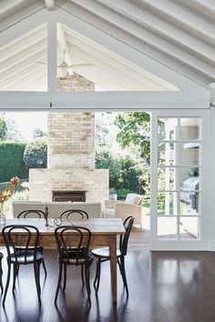 the dining room table is surrounded by chairs and an open fireplace in the back wall