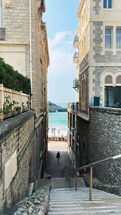 an alley way with steps leading to the beach