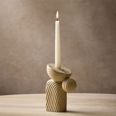 a white candle sitting on top of a wooden table