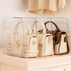 four purses sitting on top of a white shelf