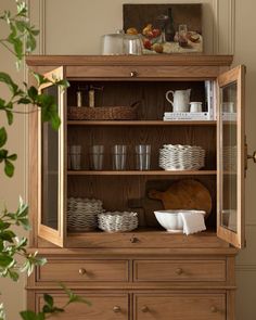 a wooden hutch with dishes and cups on it