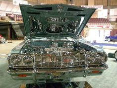 an old car with its hood open in a showroom