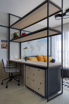 a room with a desk, chair and bed in it that has a world map on the wall