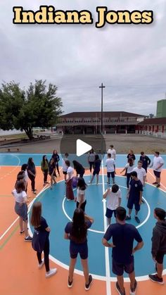 a group of people standing on top of a blue and orange basketball court with the words indiana jones