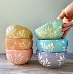 three bowls are stacked on top of each other and one has a hand reaching for the bowl