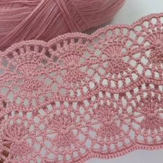 pink crocheted lace next to a ball of yarn