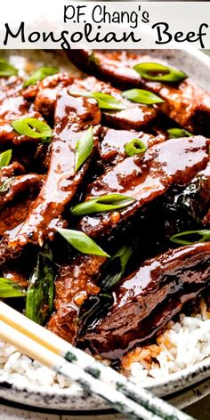 beef with sauce and green onions served on rice in a white bowl next to chopsticks