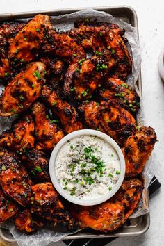 grilled chicken wings with ranch dressing on a tray