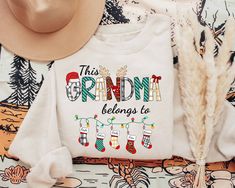 Grandma Christmas Sweatshirt, This Grandma Belongs To Shirt, Grandma Claus Shirt, Custom Grandma Shirt With Grandkids Name, Personalized Christmas Gifts For Grandma  ♥ All items are made to order. ♥ Production & shipping time:  - Production time is 3 - 5 business days from order date - Shipping time:  + Standard shipping: 5 - 7 business days + Express shipping: 3 - 5 business days ♥ Shirt Sizing: Unisex fit and run true to size. If you are unsure on sizing, please use our sizing chart in the pro Vet Tech Shirt, Christmas Gifts For Aunts, Book Christmas Tree, Gigi Shirts, Auntie Shirts, Christmas Gifts For Grandma, Christmas Party Shirts, Aunt Shirts, Christmas Tree Shirt