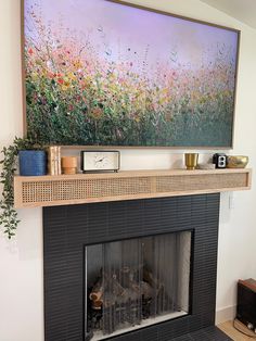 a fireplace with a painting on the wall above it