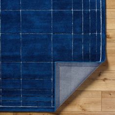 a blue area rug on top of a wooden floor next to a piece of cloth