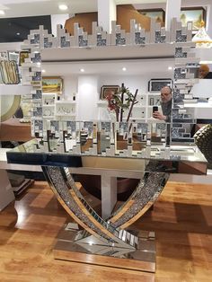 a glass table that has some pictures on it and people in the background looking at them