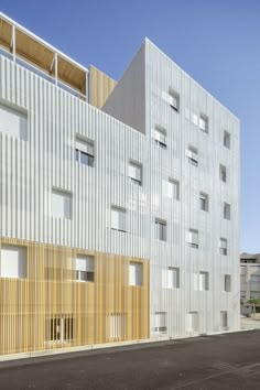 two white buildings with wooden slats on the sides