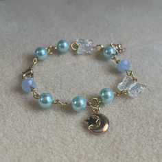 - One Of A Kind Beaded Charm Bracelet - Featuring Light Blue Pearl Beads, Clear White Butterfly Beads, A Gold Metal Crescent Moon Charm, A Star Charm That Says “Just For You,” And Gold Metal Links - Gold Colored Hardware - Clasps Closed. No Stretch. - Size/ Circumference Is 6.5” (See Picture) - Handmade (By Myself). Perfect To Treat Yourself Or To Give As A Gift! **Add 2 Jewelry Items Marked “2 For $20” To Your Bundle And I Will Send You An Offer For $20** Check Out The “Boutique” Tab In My Clos Blue And Gold Bracelets, Blue Bracelets With Star Charm And Round Beads, Cute Homemade Bracelets, Blue Jewelry With Moon Charm And Round Beads, Cute Blue Bracelets For Party, Homemade Charm Bracelets, Diy Charm Bracelet Ideas, Star Cartilage Earring, Precious Stones Bracelet