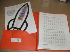 an orange binder with a calendar on it and a rocket ship in the middle