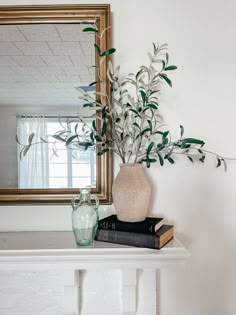 a vase filled with flowers sitting on top of a white table next to a mirror