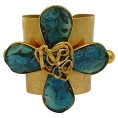 YVES SAINT LAURENT by ROBERT GOOSSENS vintage rare textured gold tone cuff bracelet featuring a massive stylized four clover centrepiece embellished with irregular shaped acqua blue resin petals and an openwork heart. Embossed YVES SAINT LAURENT RIVE GAUCHE. Made in France. Indicative measurements : inner measurements approx. min. 5.5 cm (2.17 inches) x 4.2 cm (1.65 inches) / inner measurements max. approx. 6.2 cm (2.44 inches) x 5 cm (1.97 inches) / centrepiece approx. 9.2 cm (3.62 inches) x 11 Resin Petals, Key Bracelet, Rive Gauche, Jewelry Inspo, Blue Bracelet, Gold Texture, Gold Tone Metal, Cuff Bracelet, Made In France