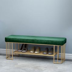 a green bench with gold legs and shoes on it