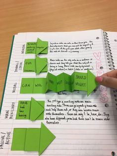 someone is making origami pieces out of green paper and pointing to the left